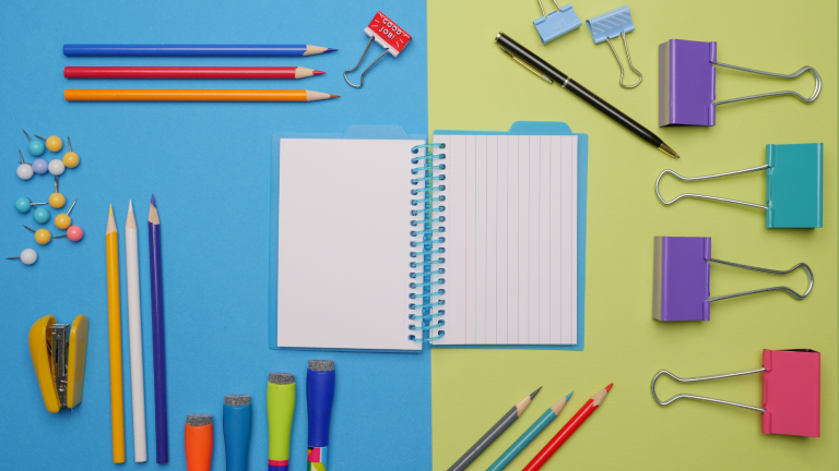 common onboarding products such as pens, notebooks and desk accessories on bright background.