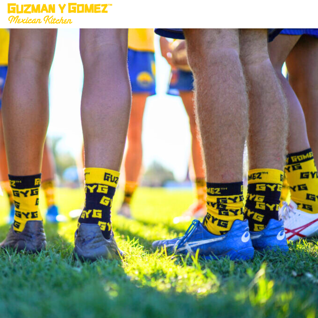 Football players legs with guzman y gomez socks